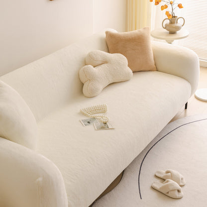 White sofa with decorative pillows and a small table in a bright room
